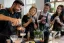 Barmannen en deelnemers shaken en inschenken van cocktails tijdens workshop op barcounter