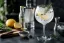Gin tonic met ijs, citroen, jeneverbessen en rozemarijn in groot ballon glas