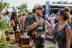 Man en vrouw toasten met rumglazen bij houten vat en rumbottels op buitenfestival